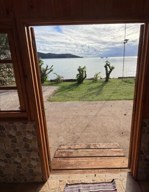 Bungalow Tauna : porte ouverte sur la pelouse et le lagon